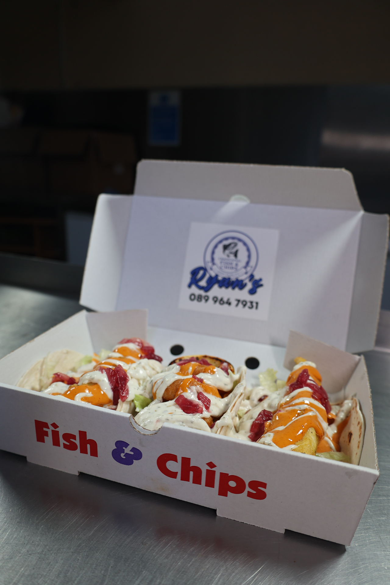 Ryan's fish tacos loaded with sauces and pickled onion